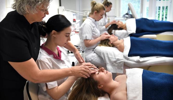 Docent begeleidt cursist tijdens les lymfedrainage