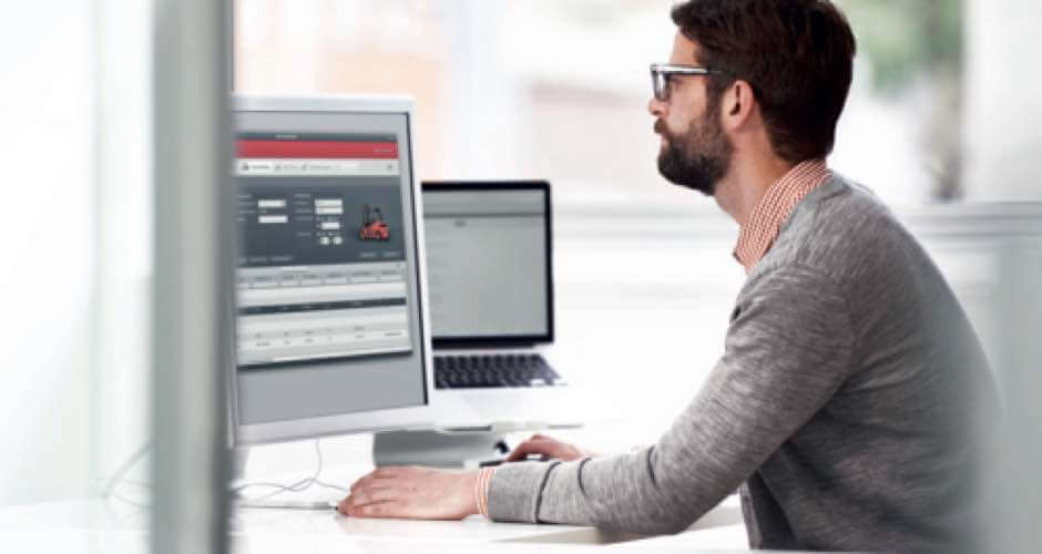 Man achter computer werkt met fleetmanagement systeem