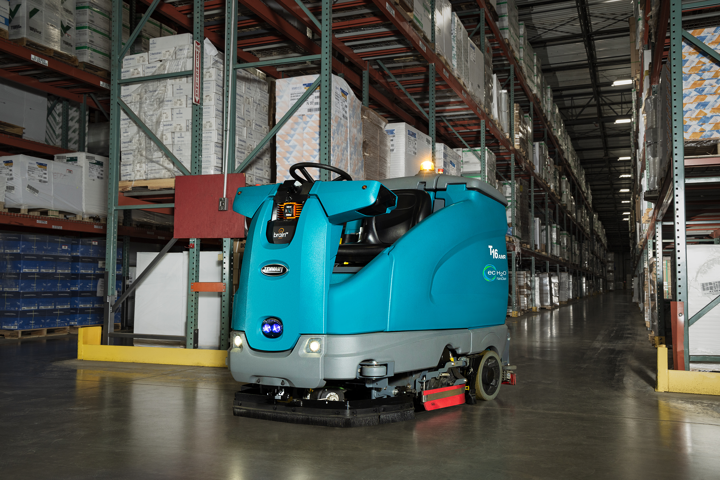 Tennant T16 AMR schrobmachine in een magazijn tussen de stellingen