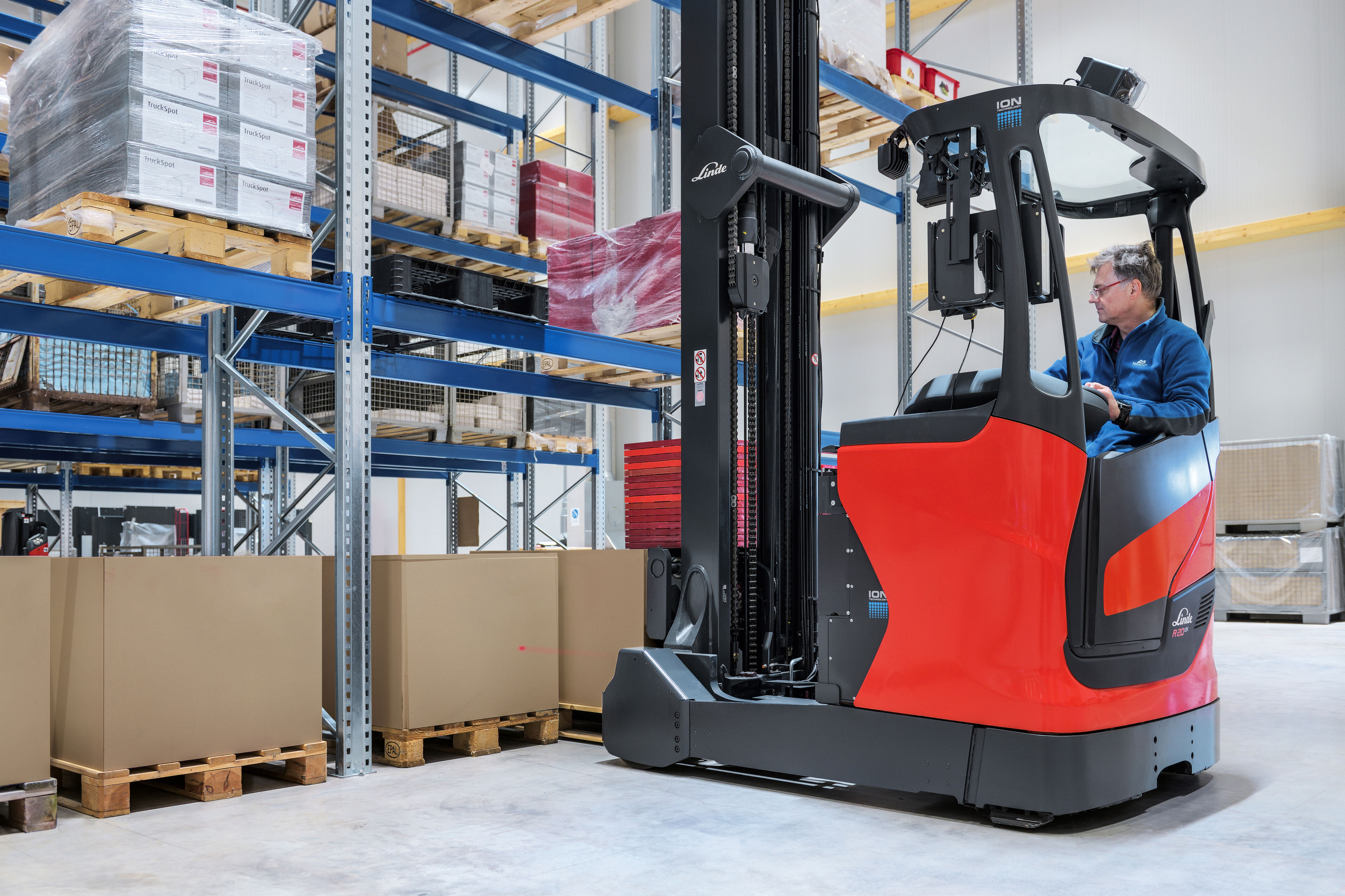 Medewerker Linde bestuurt reachtruck en lift vracht in magazijn - Nieuwe opties Linde reachtrucks