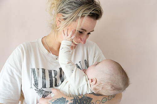 Pedagogisch professional met baby op de arm.